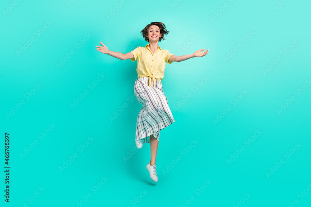 Full length photo of young girl happy positive smile jump up open hands hug isolated over teal color background