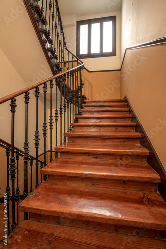Vintage wooden stairs and wrought iron railing in old and central building
