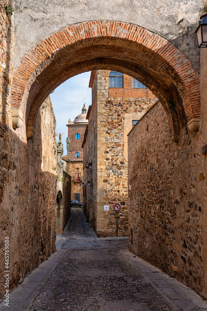 Narrow alley with old stone buildings at Caceres, Extremadura, Spain.
