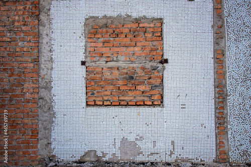 A wall with a walled-up window opening.