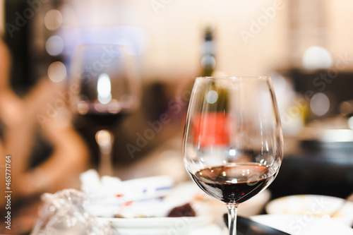 Glasses of red wine with food on table closeup in blur background.
