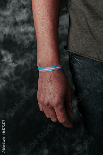 person wearing a transgender pride wristband