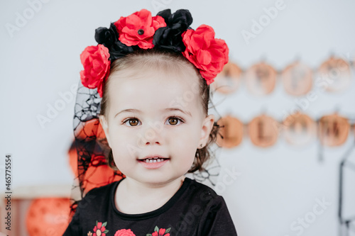 portrait of beautiful one year old caucasian girl in halloween costume at home with Halloween decoration  Lifestyle indoors. Halloween party concept.
