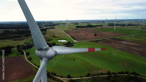 A 4K video of multiple wind turbines with red edges spinning in a wide rural field photo