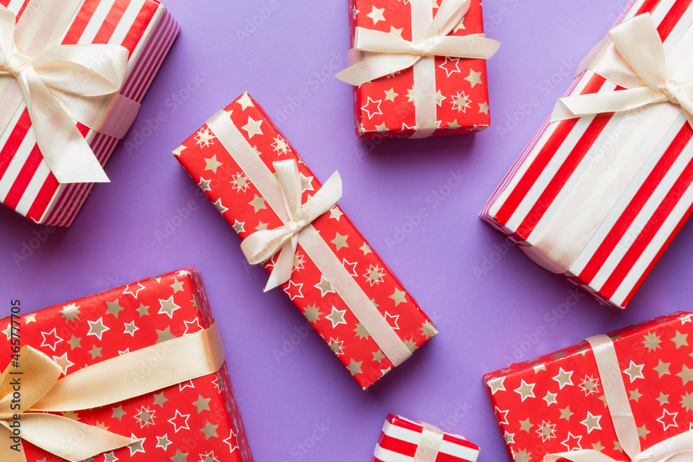 Fototapeta premium A lot of Christmas gift boxes in colored paper decorated on table, Top view close up. Many present New Year gift