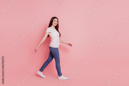 Full length profile side photo of minded serious lovely girl go walk copyspace wear casual style outfit isolated over pink color background © Tetiana