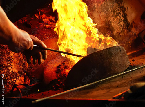 Detail of blacksmith s forge with strong flames. Mans Hands setting up fire in forge