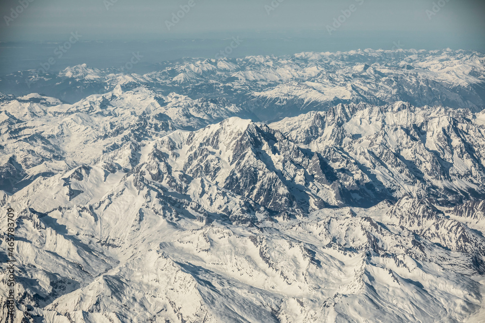 snow covered mountains in winter from airplane