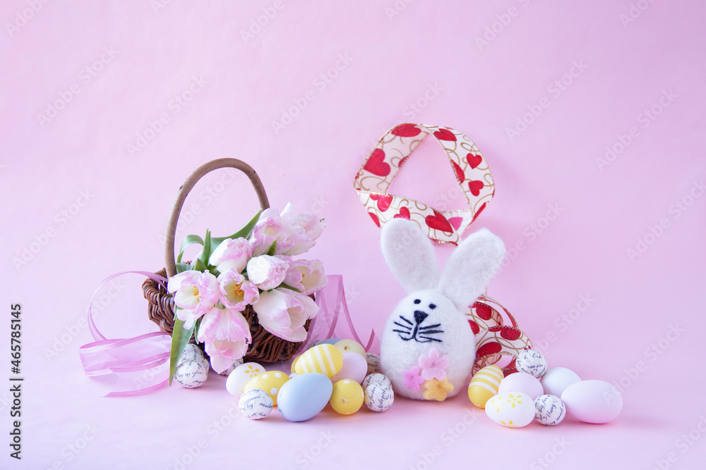イースターのウサギと卵とハート模様のリボンとピンクのチューリップの花かご