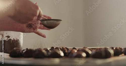 Wallpaper Mural Slow motion handheld shot of young woman sprinkle cocoa powder on chocolate truffles Torontodigital.ca