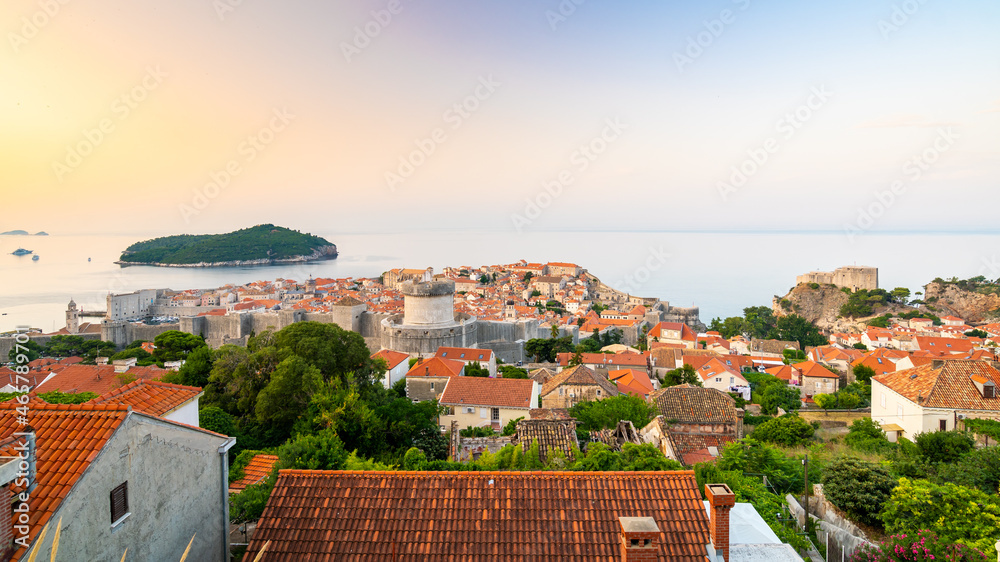 Panoramic view of sunrise over old town of Dubrovnik. Ancient city wall and Minceta tower. Famous tourist destination in Croatia. Summer morning, soft warm light. UNESCO heritage.