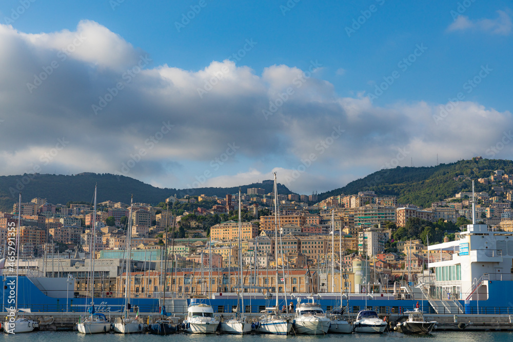 View of the port of Genoa full of yachts, boats - in the background high-rise buildings