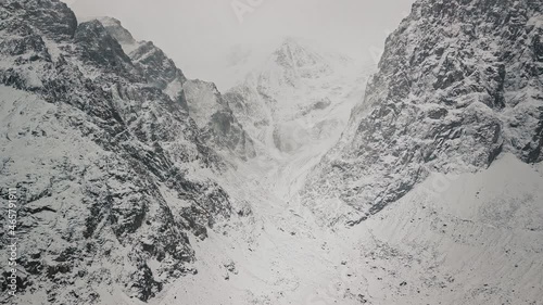 Storm, snowfall in the huge glacier of Mount Belukha, the valley of the Aktru River, the Altai Mountains. Cloudy weather, stone in the snow, storm, wildlife, winter forest, frozen mountain river in