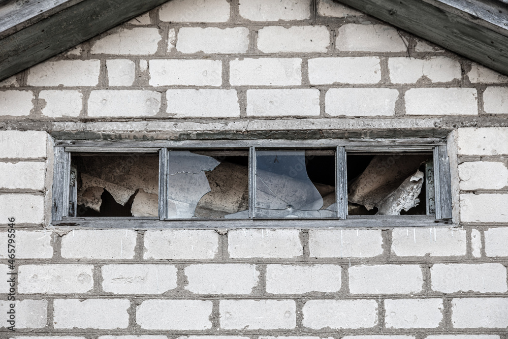 An old broken window in a brick house An old broken window in a brick house