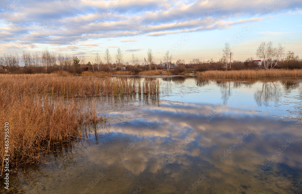 Clouds in the sky with reflection in the lake at sunset.