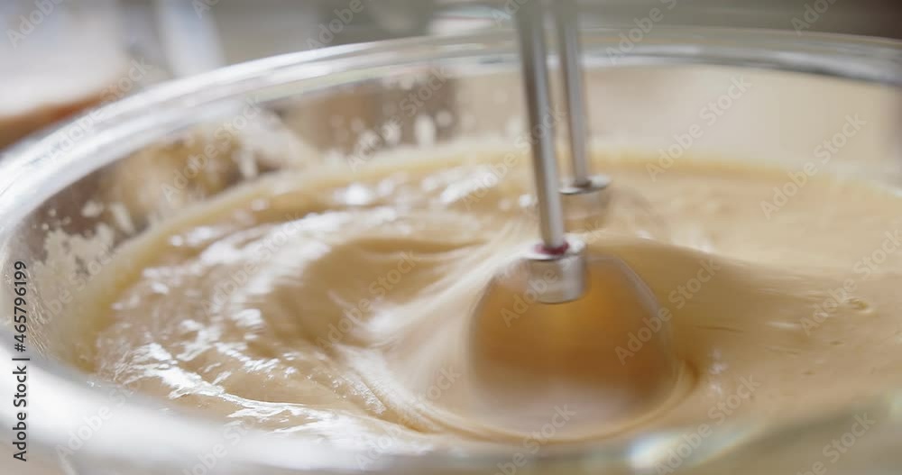 close up pastry chef preparing mixing Beating batter egg yolks flour sugar with hand mixer at the kitchen, Making homemade Sponge Cake