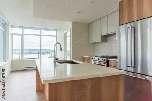 Modern, bright, clean empty kitchen interior with stainless steel appliances in a luxury house.