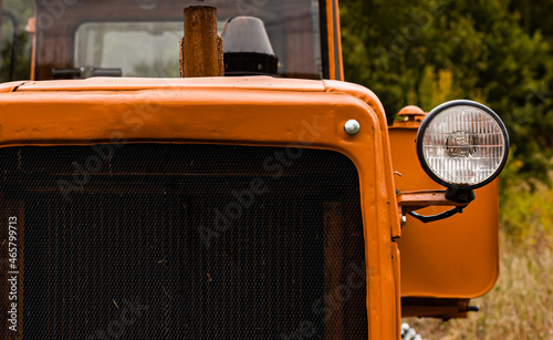 the front of an old tractor standing in a field