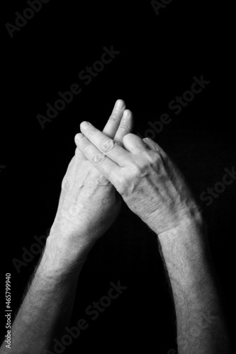 B+W image of hand demonstrating BSL sign language letter F isolated against black background