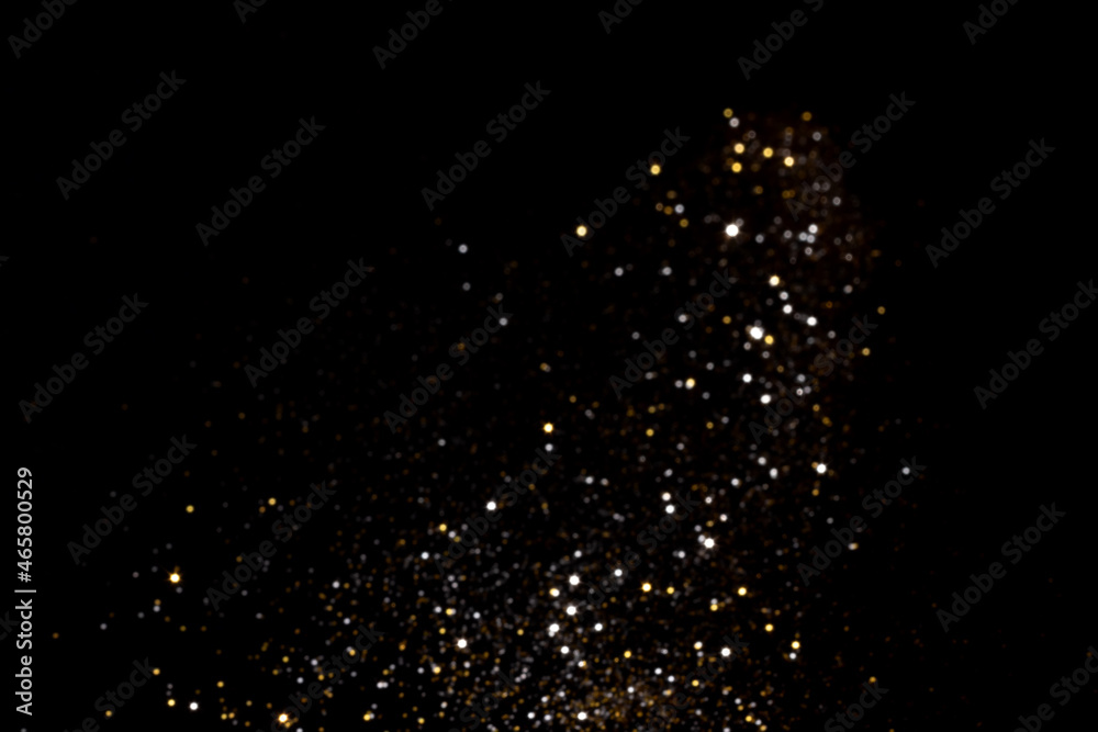 Golden and silver blurred bokeh lights on black background. Glitter sparkle stars for celebrate. Overlay for your design