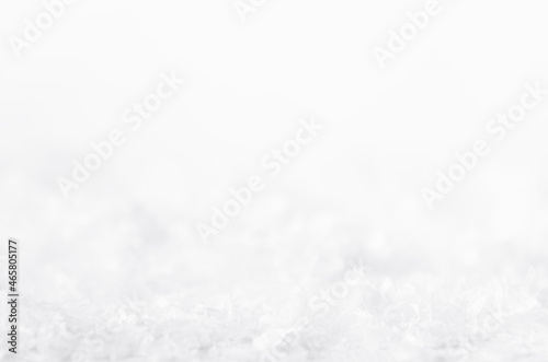 Christmas white frosty shiny bright snowflakes with blur band, surface of fake snow as abstract winter background, texture, closeup.