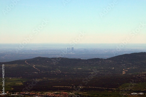 El complejo de las cuatro torres (rascacielos) de Madrid desde la distancia. Fotografía desde la distancia ascendiendo en la sierra de Guadarrama en busca del mirador de Los Canchos.