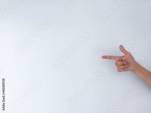 The hand of a young woman pointing with her index finger at an empty space.