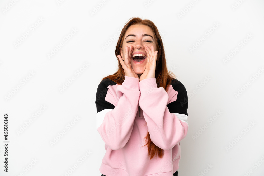 Young redhead woman isolated on white background shouting and announcing something Young redhead woman isolated on white background shouting and announcing something