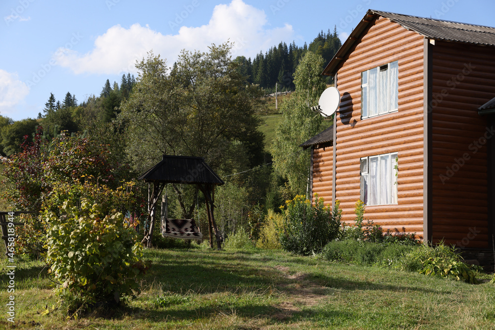 Obraz premium Modern house and swing near forest on sunny day