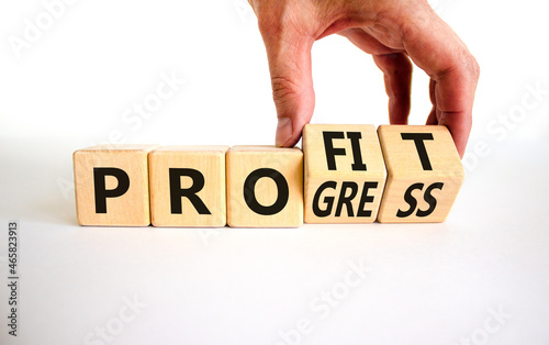 Progress and profit symbol. Businessman turns wooden cubes, changes the word 'progress' to 'profit'. Beautiful white table, white background. Business, progress and profit concept. Copy space.