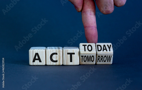 Act today not tomorrow symbol. Businessman turns wooden cubes, changes words act tomorrow to act today. Beautiful grey table, grey background. Business, act today or tomorrow concept, copy space.