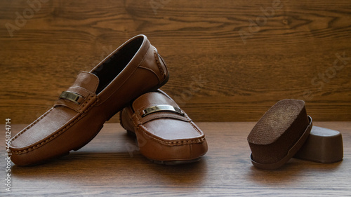 BROWN MOCCASIN SHOES, ON WOODEN FLOOR WITH NATURAL LIGHTING AND SPACE FOR TEXT