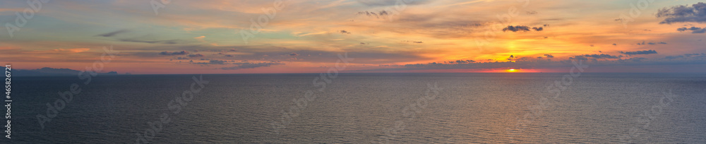Panoramic of a sunrise over the sea with clouds