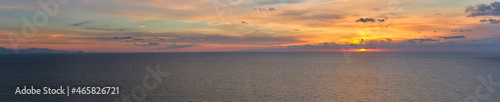 Panoramic of a sunrise over the sea with clouds