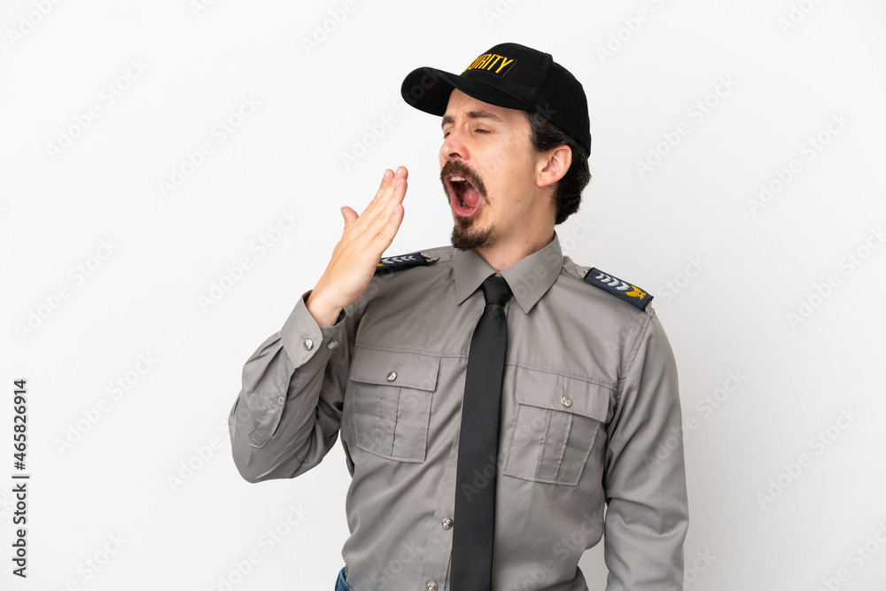 Young caucasian security man isolated on white background yawning and covering wide open mouth with hand Young caucasian security man isolated on white background yawning and covering wide open mouth with hand