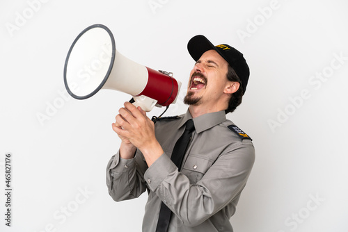 Young caucasian security man isolated on white background shouting through a megaphone