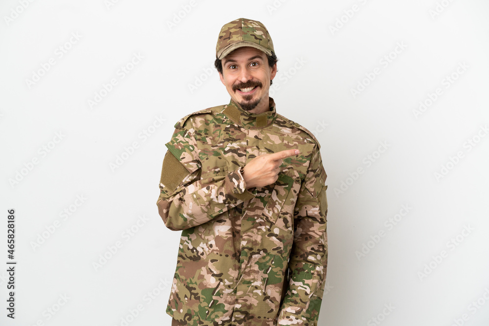 Soldier man isolated on white background pointing to the side to present a product Soldier man isolated on white background pointing to the side to present a product