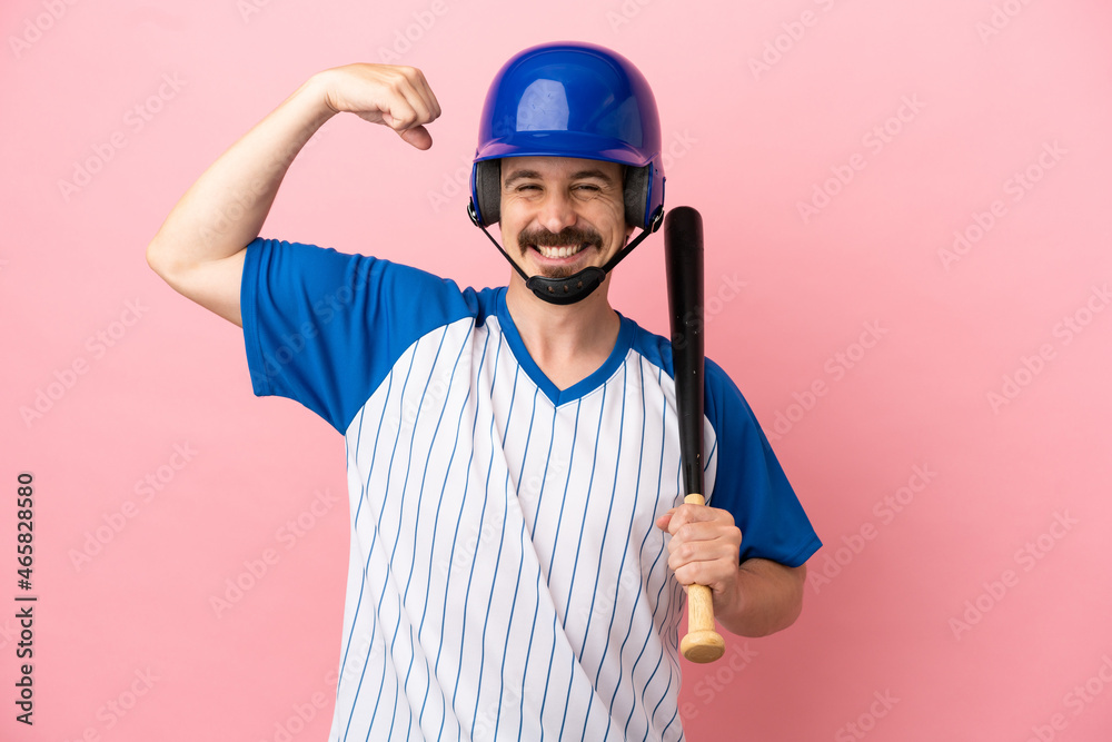 Young caucasian man playing baseball isolated on pink background doing strong gesture