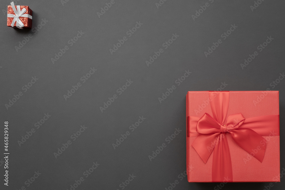 Composition of two red gift boxes, small and large, in opposite corners on a dark background. Greeting card Composition of two red gift boxes, small and large, in opposite corners on a dark background. Greeting card