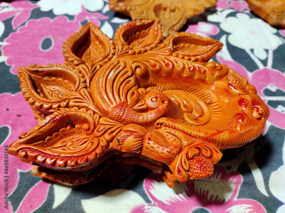Beautiful image of a handcrafted diya (clay lamp) on the table for diwali night in kolkata,india. Selective focus on middle of subject. Beautiful image of a handcrafted diya (clay lamp) on the table for diwali night in kolkata,india. Selective focus on middle of subject.