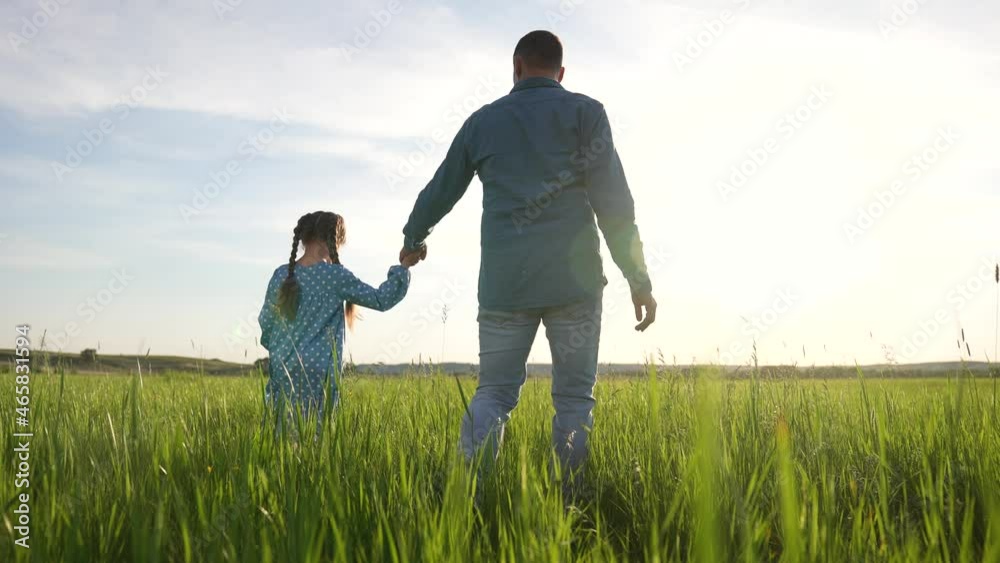 father holds hand of child. Happy family walks outdoors in park. father takes care of little girl, baby, shares love. Happy child holds his father's hand. family walks hand in hand in green park. father holds hand of child. Happy family walks outdoors in park. father takes care of little girl, baby, shares love. Happy child holds his father's hand. family walks hand in hand in green park.
