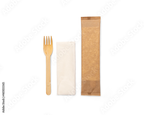 Eco-friendly wooden disposable cutlery. Fork, spoon and napkin in a craft envelope on a white background.