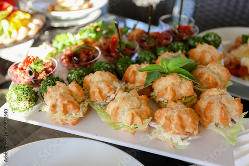 Appetizers on the white plate on a buffet table. High quality photo