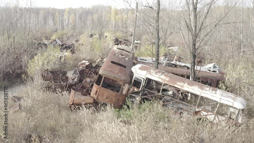 Aerial video. Old abandoned equipment that took part in the elimination of the accident. The village of Rassokha. Chernobyl. Rusty machinery.  photo