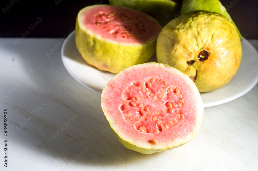 guavas on a white plate with a colorful table and a plate with guava jam, guava, selective focus and copy space guavas on a white plate with a colorful table and a plate with guava jam, guava, selective focus and copy space
