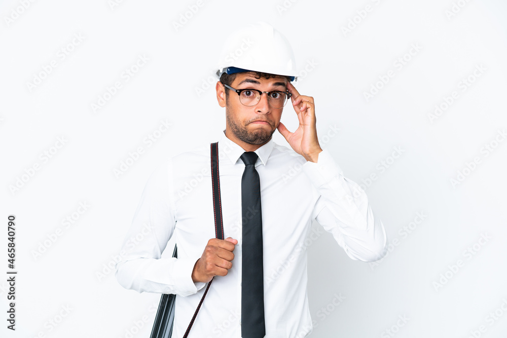 Architect brazilian man with helmet and holding blueprints thinking an idea Architect brazilian man with helmet and holding blueprints thinking an idea