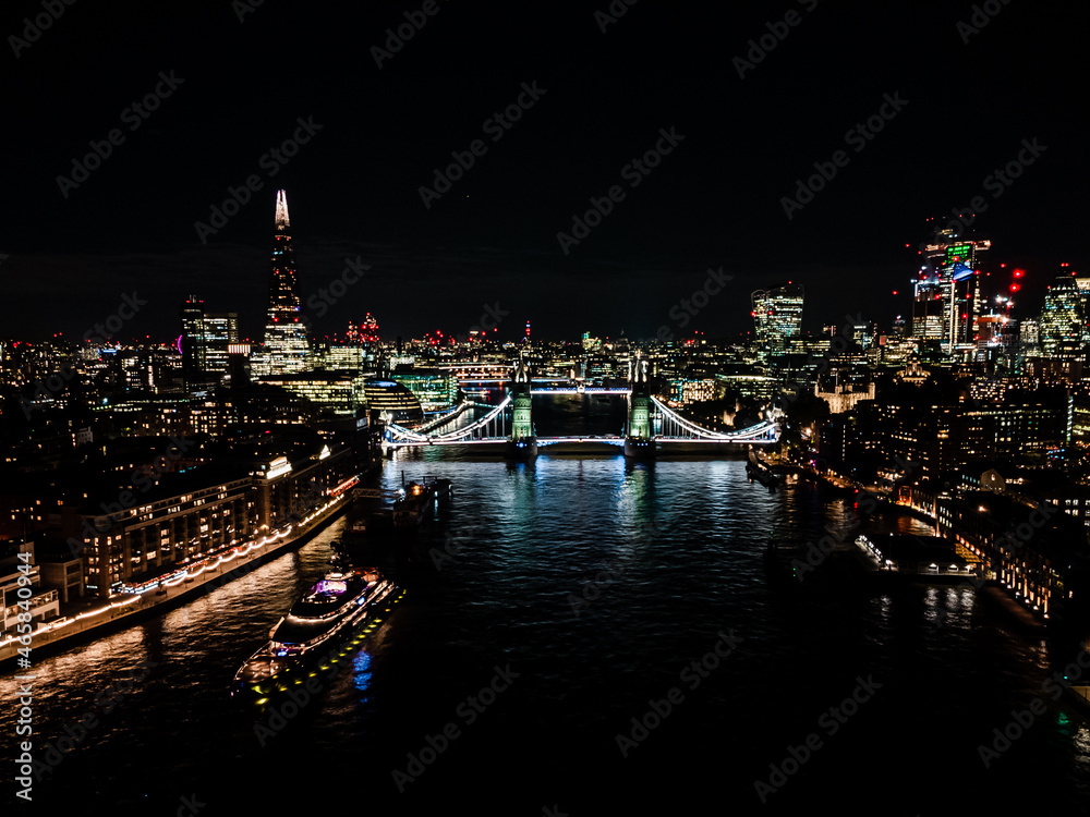 London Tower Bridge at Night with urban architectures Aerial drone view. One of London's most famous bridges and must-see landmarks in United Kingdom