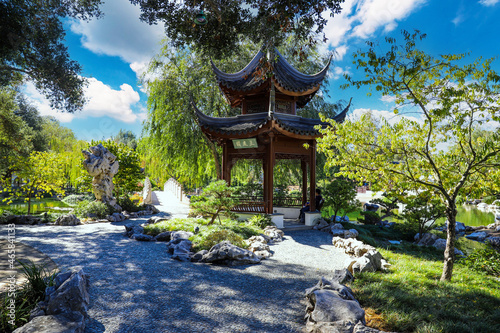 a japanese temple in the park surrounded by lush green trees and plants with blue sky and clouds at Huntington Library and Botanical Garden in San Marino California USA photo