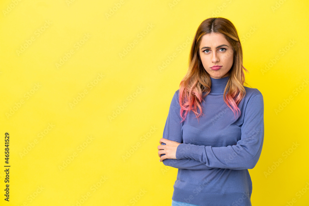 Young woman over isolated yellow background with sad expression Young woman over isolated yellow background with sad expression