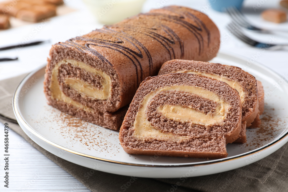 Tasty chocolate cake roll with cream on white wooden table, closeup Tasty chocolate cake roll with cream on white wooden table, closeup